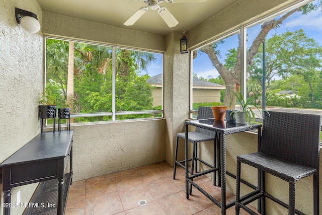 sunroom / solarium with a ceiling fan
