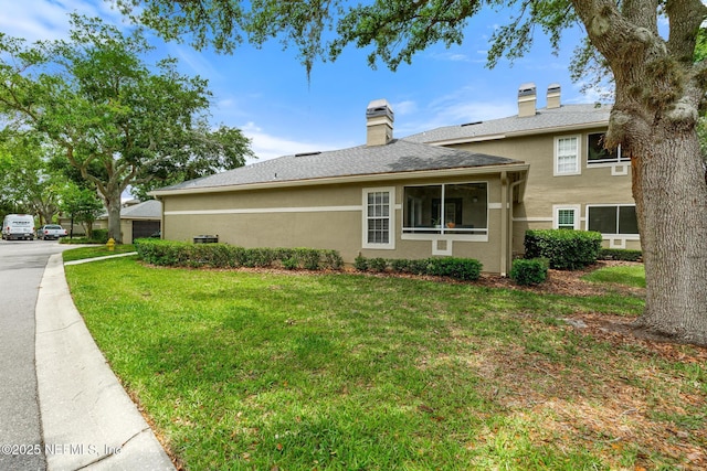 view of home's exterior featuring a yard, stucco siding, and a chimney