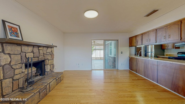 kitchen featuring electric range, freestanding refrigerator, light countertops, light wood-style floors, and under cabinet range hood