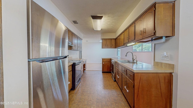 kitchen featuring freestanding refrigerator, a sink, electric stove, dishwashing machine, and light countertops
