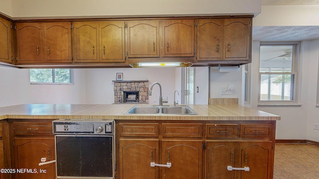 kitchen featuring a sink, light countertops, brown cabinets, and baseboards
