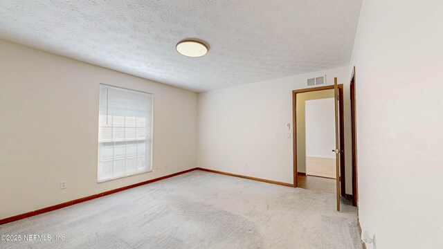 unfurnished room with carpet flooring, a textured ceiling, and baseboards