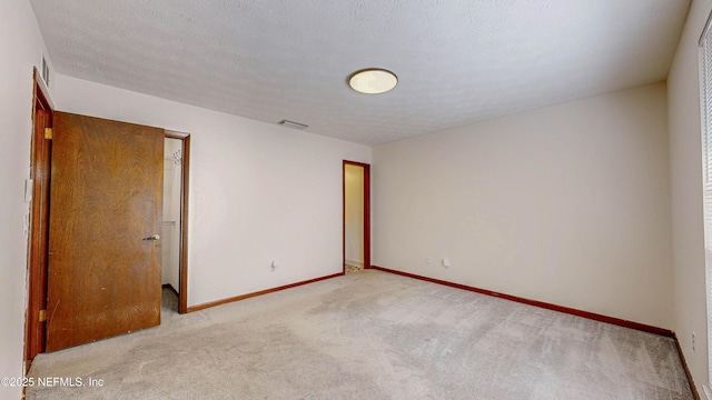 spare room with light carpet and baseboards