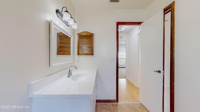 bathroom with vanity, tile patterned flooring, and baseboards