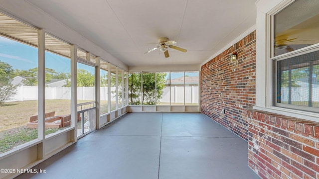 unfurnished sunroom with ceiling fan