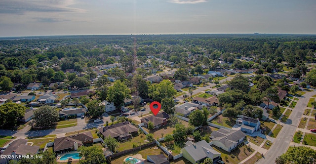 aerial view of property's location featuring nearby suburban area and a heavily wooded area