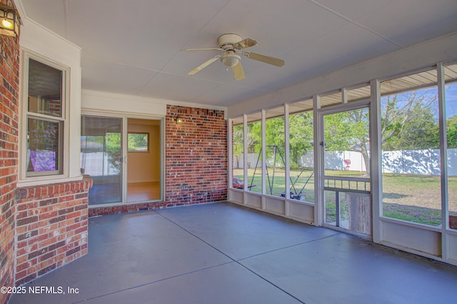 unfurnished sunroom featuring a ceiling fan