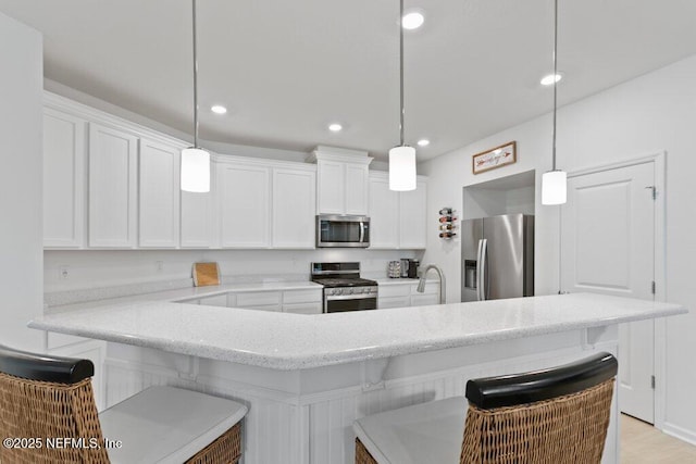 567 Flach Dr, Saint Johns, FL 32259 - kitchen with stainless steel appliances, white cabinets, a kitchen breakfast bar, light stone countertops, and recessed lighting