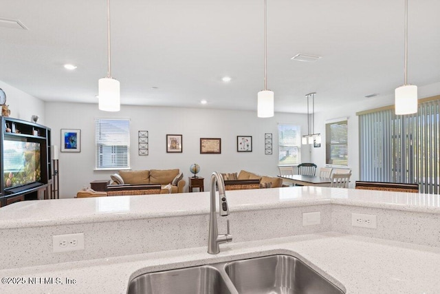 567 Flach Dr, Saint Johns, FL 32259 - kitchen with a sink, light stone counters, open floor plan, recessed lighting, and hanging light fixtures