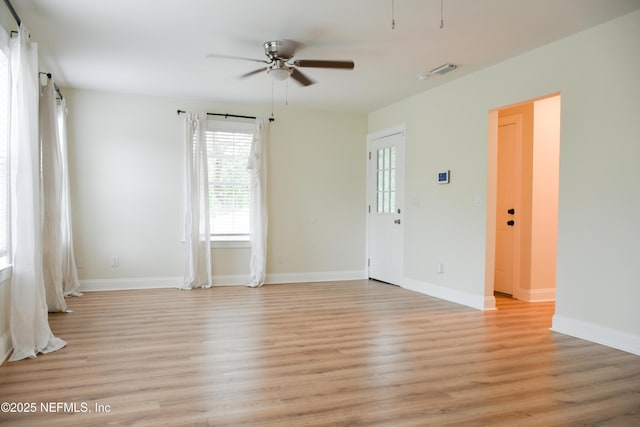 unfurnished room with ceiling fan, light wood-type flooring, and baseboards