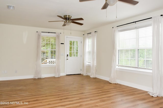 doorway to outside with ceiling fan, light wood-type flooring, and baseboards