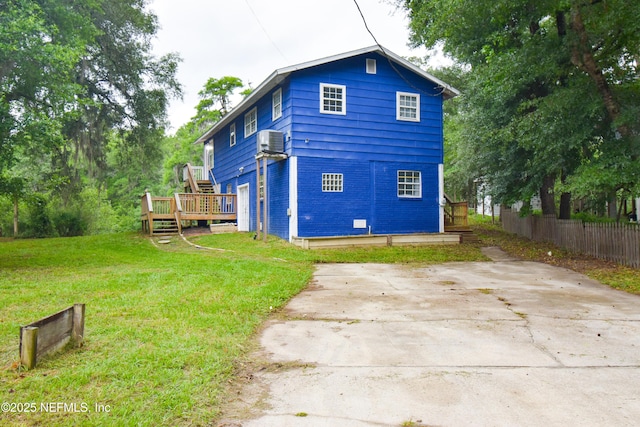rear view of house with a wooden deck and cooling unit