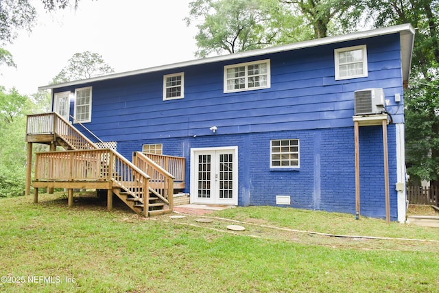 rear view of property with french doors, stairway, brick siding, and a lawn