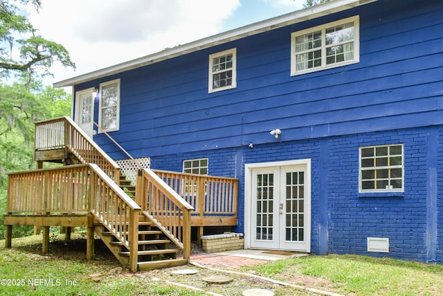 rear view of property with stairs, brick siding, french doors, a wooden deck, and crawl space