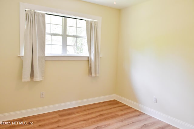 spare room with light wood finished floors and baseboards