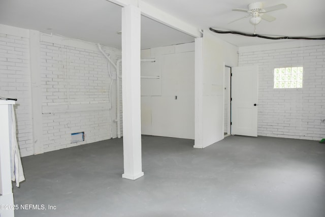 below grade area with brick wall and ceiling fan