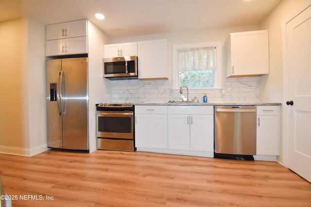 2873 Creek St, Middleburg, FL 32068 - kitchen featuring appliances with stainless steel finishes, a sink, recessed lighting, white cabinets, and decorative backsplash