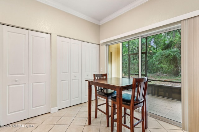 dining space featuring ornamental molding and light tile patterned floors