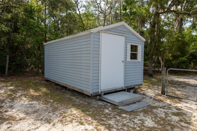 7013 Elfo Rd, Keystone Heights, FL 32656 - view of shed featuring view of scattered trees, a gate, and fence