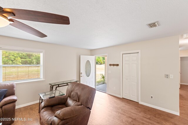 7013 Elfo Rd, Keystone Heights, FL 32656 - living area with wood finished floors, ceiling fan, a textured ceiling, and baseboards