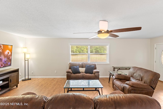 7013 Elfo Rd, Keystone Heights, FL 32656 - living room with ceiling fan, light wood-type flooring, baseboards, and a textured ceiling