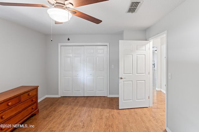 7013 Elfo Rd, Keystone Heights, FL 32656 - unfurnished bedroom with light wood finished floors, a closet, baseboards, and a ceiling fan