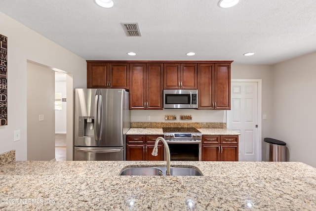 7013 Elfo Rd, Keystone Heights, FL 32656 - kitchen featuring appliances with stainless steel finishes, a sink, light stone counters, recessed lighting, and a textured ceiling