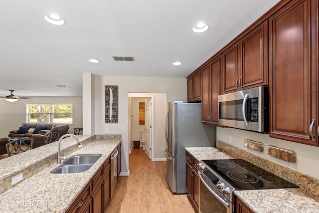 7013 Elfo Rd, Keystone Heights, FL 32656 - kitchen featuring appliances with stainless steel finishes, a sink, light stone counters, light wood-style flooring, and open floor plan