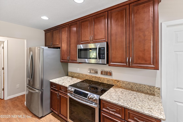 7013 Elfo Rd, Keystone Heights, FL 32656 - kitchen with appliances with stainless steel finishes, light wood-style floors, recessed lighting, and light stone countertops
