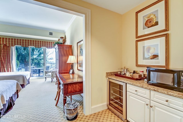 2358 Riverside Ave Unit 304, Jacksonville, FL 32204 - indoor dry bar with beverage cooler, black microwave, light carpet, ornamental molding, and baseboards