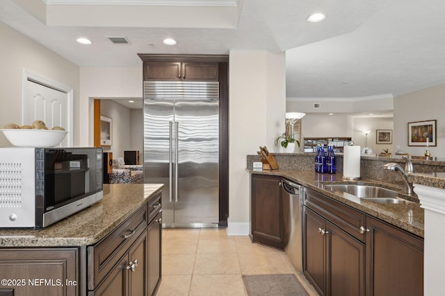 2358 Riverside Ave Unit 304, Jacksonville, FL 32204 - kitchen featuring stainless steel appliances, a sink, dark stone countertops, light tile patterned floors, and recessed lighting
