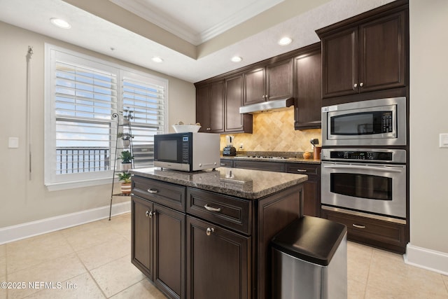2358 Riverside Ave Unit 304, Jacksonville, FL 32204 - kitchen featuring appliances with stainless steel finishes, crown molding, baseboards, under cabinet range hood, and decorative backsplash