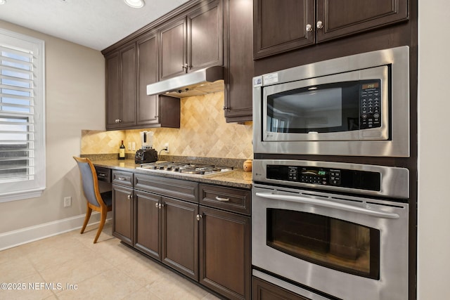 2358 Riverside Ave Unit 304, Jacksonville, FL 32204 - kitchen with stainless steel appliances, baseboards, under cabinet range hood, and decorative backsplash
