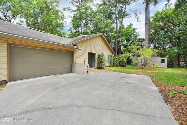 11711 Sparkleberry Ln, Jacksonville, FL 32223 - view of side of property featuring driveway, an attached garage, and a lawn