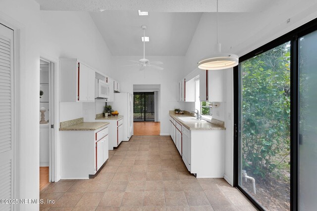 11711 Sparkleberry Ln, Jacksonville, FL 32223 - kitchen featuring light countertops, white appliances, a ceiling fan, lofted ceiling, and a sink