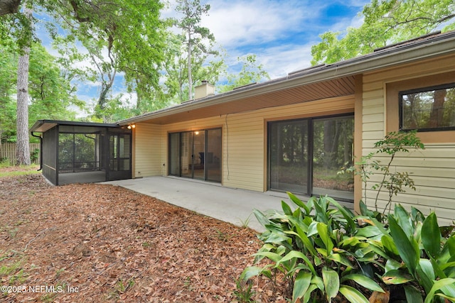 11711 Sparkleberry Ln, Jacksonville, FL 32223 - back of house featuring a sunroom, a chimney, and a patio area