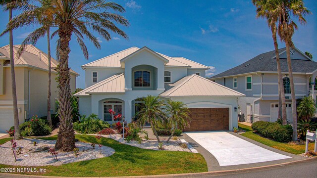 9155 June Ln, Saint Augustine Beach, FL 32080 - view of front of house with a standing seam roof, stucco siding, metal roof, an attached garage, and concrete driveway