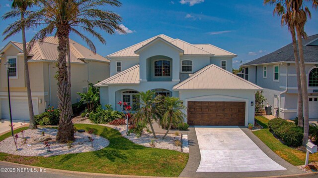 9155 June Ln, Saint Augustine Beach, FL 32080 - view of front of property with a standing seam roof, stucco siding, a garage, metal roof, and driveway