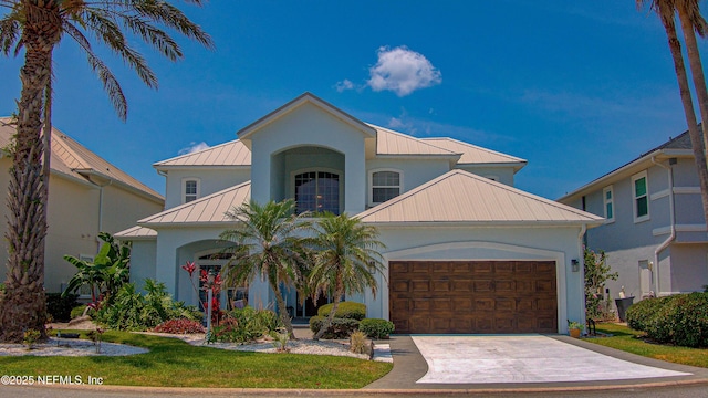 9155 June Ln, Saint Augustine Beach, FL 32080 - view of front of home featuring a standing seam roof, metal roof, an attached garage, concrete driveway, and stucco siding