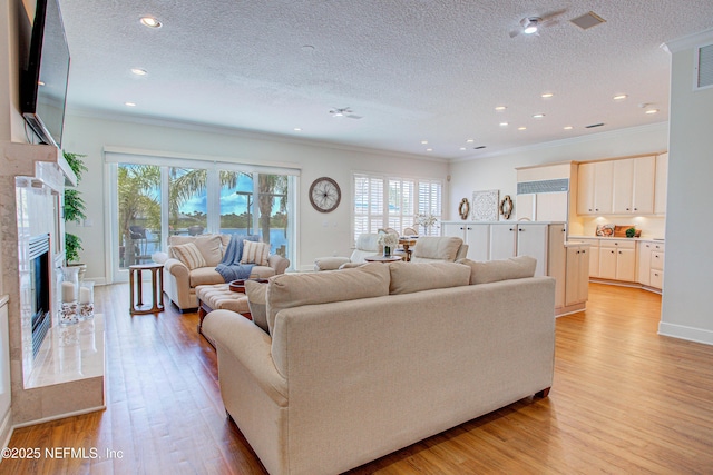 9155 June Ln, Saint Augustine Beach, FL 32080 - living room with healthy amount of natural light, a textured ceiling, light wood finished floors, ornamental molding, and recessed lighting