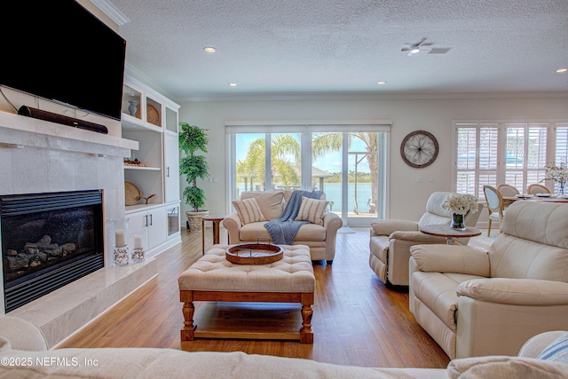 9155 June Ln, Saint Augustine Beach, FL 32080 - living area with crown molding, wood finished floors, a textured ceiling, a high end fireplace, and recessed lighting
