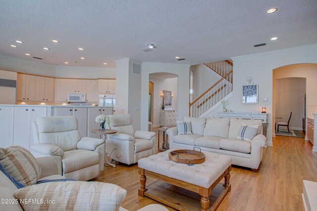 9155 June Ln, Saint Augustine Beach, FL 32080 - living area with arched walkways, crown molding, stairway, a textured ceiling, and recessed lighting