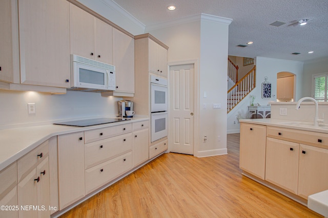 9155 June Ln, Saint Augustine Beach, FL 32080 - kitchen featuring white appliances, a sink, light wood-type flooring, ornamental molding, and light countertops