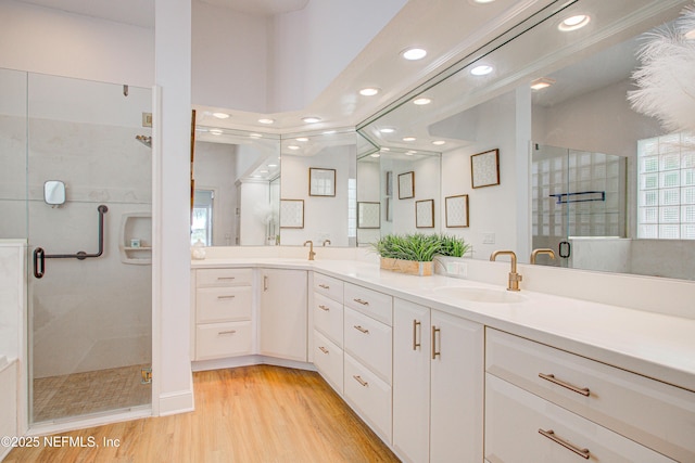 9155 June Ln, Saint Augustine Beach, FL 32080 - bathroom featuring recessed lighting, a stall shower, wood finished floors, and double vanity