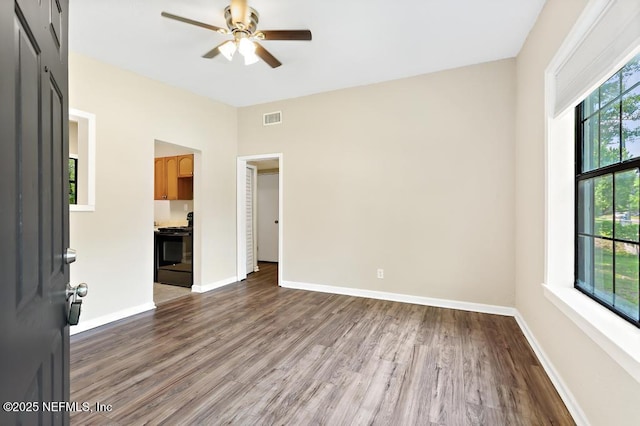 unfurnished living room with a ceiling fan, wood finished floors, and baseboards