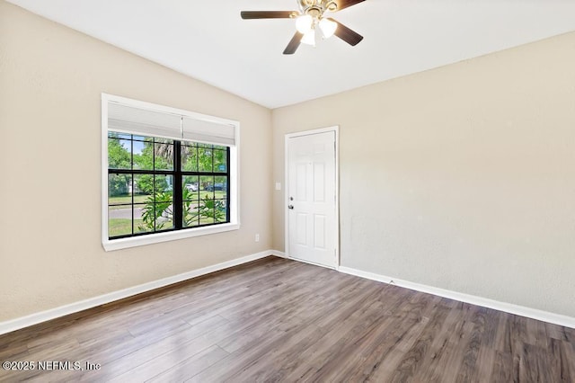 spare room with wood finished floors, ceiling fan, and baseboards