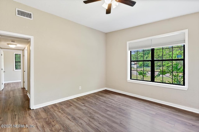 unfurnished room with ceiling fan, dark wood-style floors, and baseboards