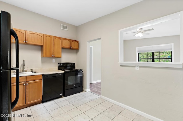 kitchen with black appliances, a sink, light countertops, baseboards, and ceiling fan
