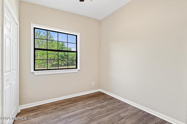 unfurnished room featuring wood finished floors, baseboards, and ceiling fan