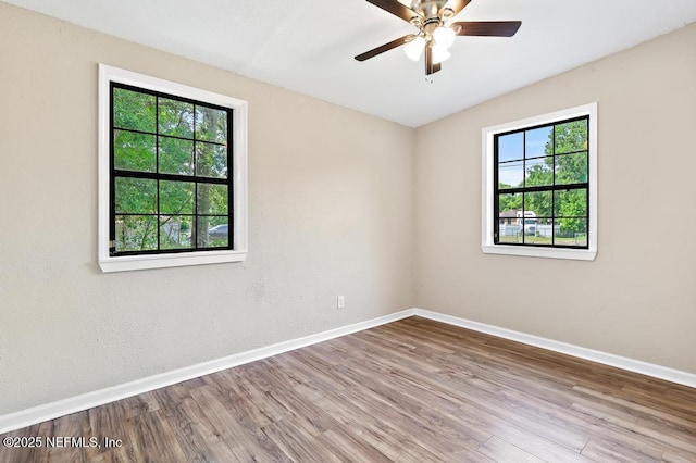 unfurnished room with baseboards, wood finished floors, and ceiling fan
